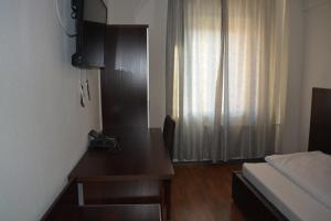 Zimmer mit einem Schreibtisch, einem Bett und einem Fenster in der Unterkunft B&D Hotel in Hannover