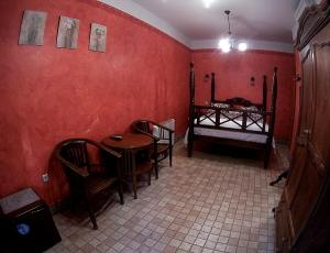 une salle à manger avec des murs rouges, une table et des chaises dans l'établissement Hosteria Natura, à Ségovie