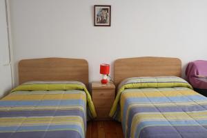 2 nebeneinander sitzende Betten in einem Schlafzimmer in der Unterkunft Hostal Bayón in León
