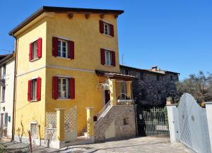 een geel gebouw met rode ramen en een hek bij House Versilia Luca E Giada, 5 chilometri da Forte dei Marmi! in Forte dei Marmi