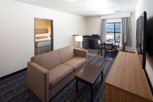 a living room with a couch and a bedroom at Red Lion Ridgewater Inn & Suites Polson in Polson