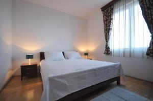 a bedroom with a bed and a large window at Apartments Spas in Budva