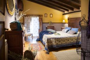 ナバコンセホにあるCasa Rural la Casa del Bosqueのベッドルーム1室(ベッド1台、椅子1脚付)