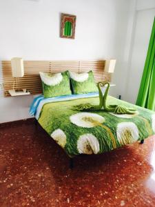 a bedroom with a bed with a green comforter at Axarquia Apartments in Nerja