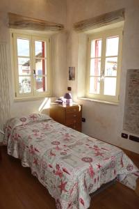 a bedroom with a bed and a dresser and two windows at House Versilia Luca E Giada, 5 chilometri da Forte dei Marmi! in Forte dei Marmi +42 photos