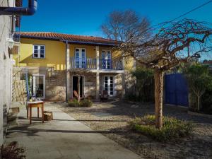 a yellow house with a tree in front of it at Quinta da Pereirinha in Arcos de Valdevez