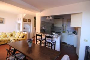 a kitchen and a living room with a table and a couch at Five Lands Pink Cottage in Levanto