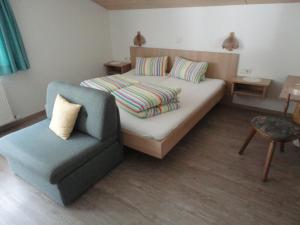 a small bedroom with a bed and a chair at Appartement Alpenrose in Imsterberg