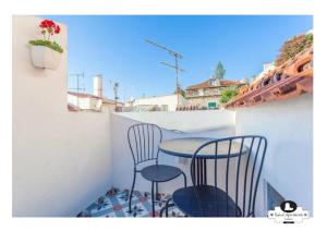 a small balcony with two chairs and a table at Beco das Flores Typical Apartment in Lisbon