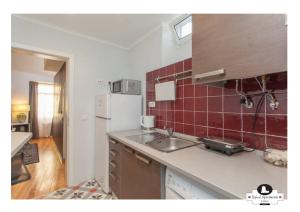 a kitchen with a sink and a refrigerator at Beco das Flores Typical Apartment in Lisbon