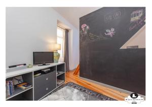 a living room with a chalkboard wall with a tv at Beco das Flores Typical Apartment in Lisbon