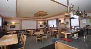 a restaurant with tables and chairs and a bar at Appartement Alpenrose in Imsterberg