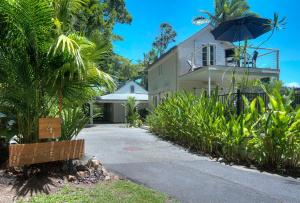 a house with an umbrella next to a driveway at Port Douglas Cottage & Lodge in Port Douglas