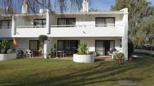 una casa bianca con un prato davanti di By the Beach a Almancil