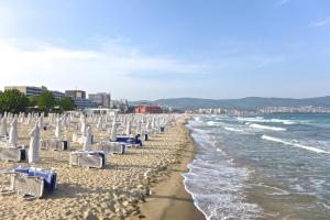 a beach with lounge chairs and the ocean at Persani Sunny Beach in Sunny Beach