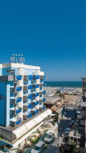 een uitzicht op een hotel met de oceaan op de achtergrond bij Hotel Helios in Rimini