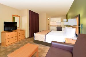 a hotel room with a bed and a flat screen tv at Extended Stay America Suites - Sacramento - South Natomas in Sacramento