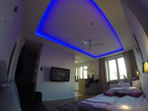 Schlafzimmer mit blauem Licht an der Decke in der Unterkunft A3XD Apartament in Częstochowa
