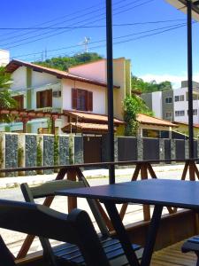 a table and chairs on a deck with a building at Kasa Hostel Bar e Karaoke in Balneário Camboriú
