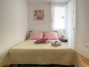 een slaapkamer met een bed met roze kussens erop bij Apartment Mia Makarska in Makarska