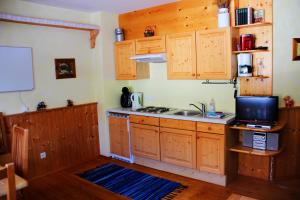 a kitchen with wooden cabinets and a sink and a microwave at Juniorsuite in Turracher Hohe