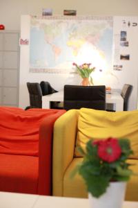 ハンブルクにあるMAC シティ ホステルのカラフルな椅子と花のテーブルが備わる客室です。