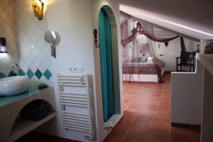 a bathroom with a sink and a room with a bed at Boutique Bed & Breakfast Casa Utopia in Alcaucín