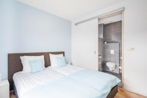 MeliskerkeにあるMeliskerke vakantiewoningの白いベッド(青い枕付)が備わるベッドルームです。