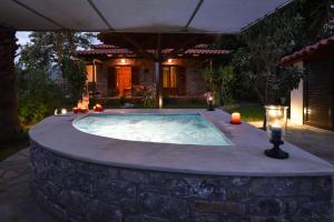 a hot tub in a patio with candles and lights at Villa Onar, Stone Villa with Sea View & Private Jacuzzi in Stoupa