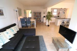 a living room with a black couch and a table at Condo Cabrinha - Direct on Kite Beach Cabarete in Cabarete