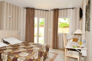 - une chambre avec un lit, un bureau, une table et une chaise dans l'établissement Hotel restaurant L'Amphitryon, à Coudray