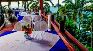 a table with a vase of flowers sitting on a balcony at Hotel Maribu Caribe in Puerto Limón