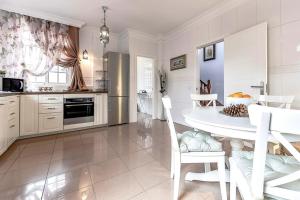 アデへにある3bedroom Villa Costa Adejeの白いキッチン(白いテーブルと椅子付)