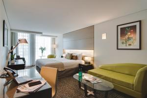 um quarto de hotel com uma cama e um sofá em The Point Brisbane Hotel em Brisbane