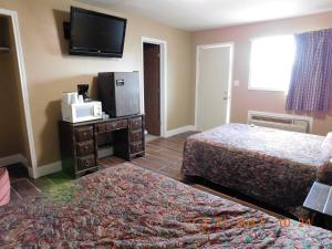 a hotel room with two beds and a flat screen tv at American Star Inn in Munday