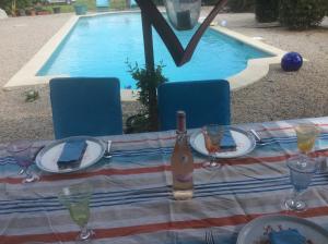 stół z butelką wina przy basenie w obiekcie B&B Maison Brora w mieście Lorgues