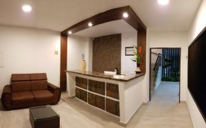 a lobby with a chair and a reception counter at Hotel Villa Blanca in Popayan