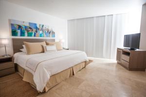 a bedroom with a large bed and a flat screen tv at Hotel Casablanca in San Andrés