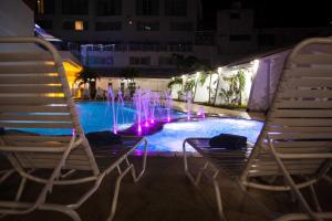 two chairs and a fountain in a pool at night at Hotel Casablanca in San Andrés