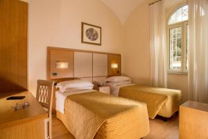 Un pat sau paturi într-o cameră la Hotel Piemonte