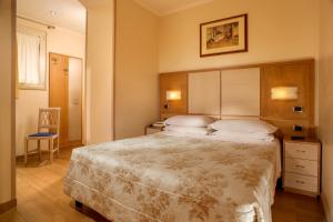 una camera con un grande letto con testiera in legno di Hotel Piemonte a Roma