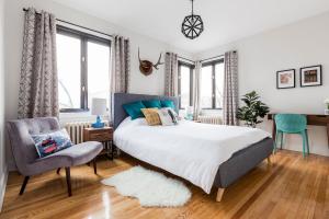 a bedroom with a bed and a chair at MTLVacationrentals-The MTLVR Kisses in Montréal