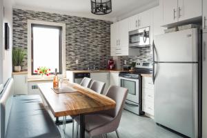 a kitchen with a wooden table and a white refrigerator at MTLVacationrentals-The MTLVR Kisses in Montreal