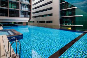 a large blue swimming pool in a building at The Klagan @ Riverson Hotel in Kota Kinabalu