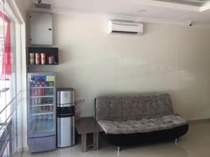 a living room with a couch and a refrigerator at Hi Star Hotel in Sitiawan