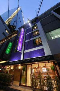 曼谷的住宿－曼谷阿達焦酒店，一面有紫色标志的建筑