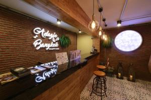 a restaurant with a brick wall and a bar with a stool at Adagio Bangkok in Bangkok