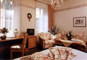 a living room with a couch and a table and a room with a tablektop at Hotel Fürstenberg in Bad Neuenahr-Ahrweiler