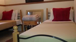 - une chambre avec 2 lits dotés d'oreillers rouges et d'un miroir dans l'établissement Genting Sempah Berjaya Hill, à Bukittinggi