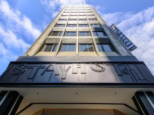a tall building with a sign on the side of it at Stay Hotel - Taichung Zhongqing in Taichung